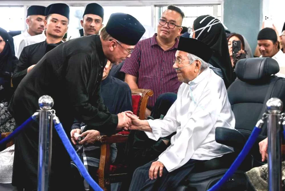 Anwar bersalaman dengan Dr Mahathir sambil menyampaikan ucapan takziah atas pemergian isterinya, Allahyarham Tun Dr Hasmah, di Masjid As-Syarif, Taman Sungai Besi Indah pada Isnin. Foto Bernama