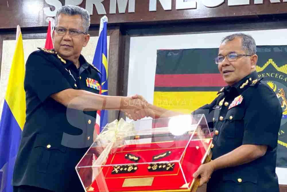 Azmi (kiri) pada Majlis Lambaian Kasih dan Serah Terima Tugas Pengarah SPRM Kelantan, Ketua Penolong Kanan Pesuruhjaya Azmin di Kota Bharu pada Isnin.