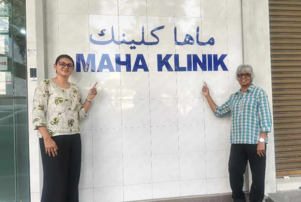 Dr Reshampreet (kiri) dan Mercy menunjukkan nama MAHA Klinik di Alor Setar.