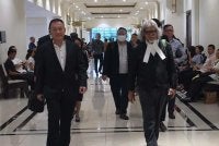 Tze Khen (kiri) bersama peguamnya, Ram ketika hadir ke Mahkamah Kota Kinabalu.