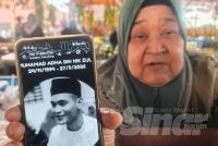 Jamaliah menunjukkan gambar arwah semasa ditemui di Pasar Tani Kekal Changlun pada Isnin.