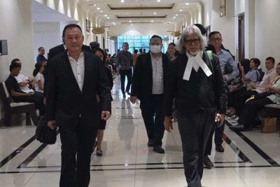 Tze Khen (kiri) bersama peguamnya, Ram ketika hadir ke Mahkamah Kota Kinabalu.