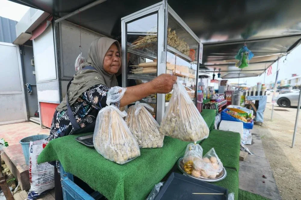 Asmah Husin menyusun sate ikan yang dijualnya di Pekan Rantau Panjang.