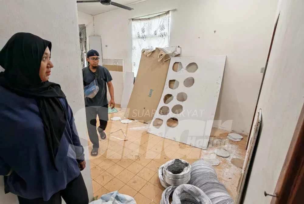 Rabiatul Adawiyah bersama suaminya melihat keadaan ruang dalam rumahnya yang mengalami kerosakan teruk.