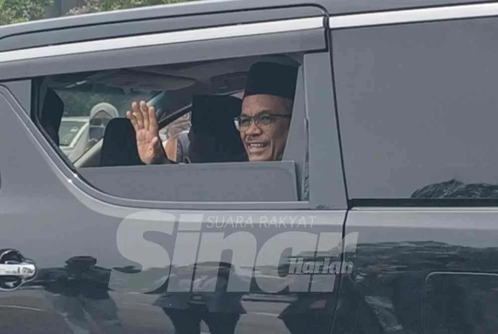 Hassan melambai tangan kepada pengamal media di luar Istana Hinggap, Seremban.