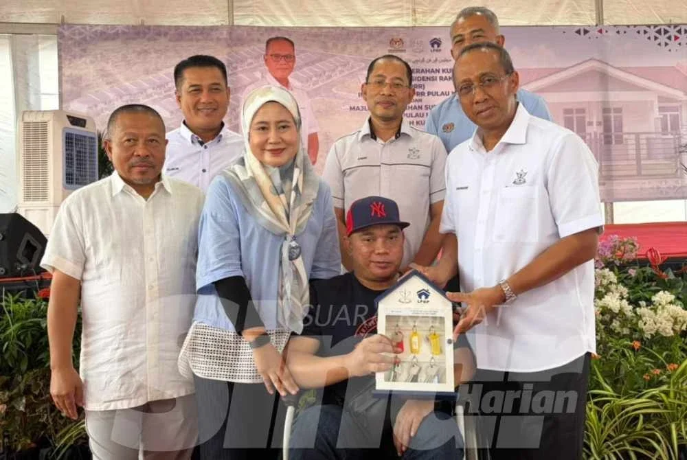 Mohammad Fakhruddin (kanan) menyampaikan kunci kepada Mohd Azuan pada majlis terbabit