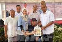 Mohammad Fakhruddin (kanan) menyampaikan kunci kepada Mohd Azuan pada majlis terbabit