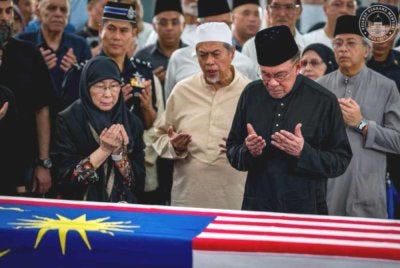 Anwar dan isteri semasa menziarahi jenazah Allahyarham Dr Hasmah. Foto Facebook Anwar Ibrahim