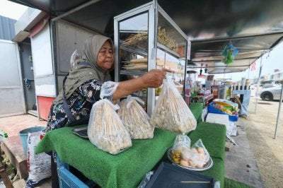 Asmah Husin menyusun sate ikan yang dijualnya di Pekan Rantau Panjang.