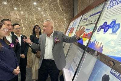 Ketua Global Pembuatan Dalaman Renesas Electronics, Ooi Heng Ee (kanan) memberi penerangan kepada Jamaliah (kiri) pada Majlis Perasmian Projek Solar Panel Tempat Letak Kereta di Renesas Semiconductor KL Sdn. Bhd Zon Perindustrian Bebas Telok Panglima Garang pada Selasa.
