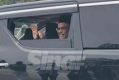 Hassan melambai tangan kepada pengamal media di luar Istana Hinggap, Seremban.