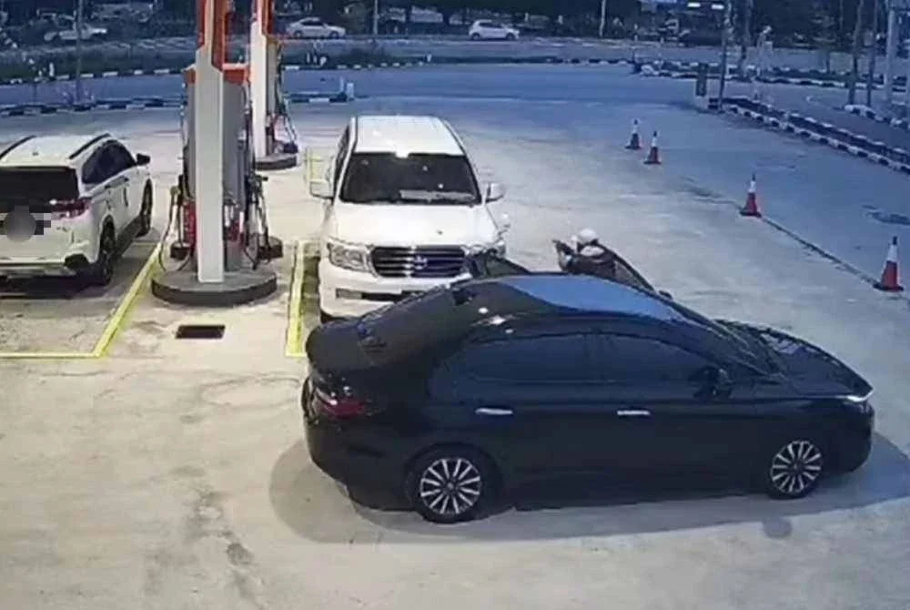 Tangkap layar CCTV memaparkan seorang lelaki mengacukan senjata api ke arah kenderaan mangsa sebelum beredar melarikan diri.