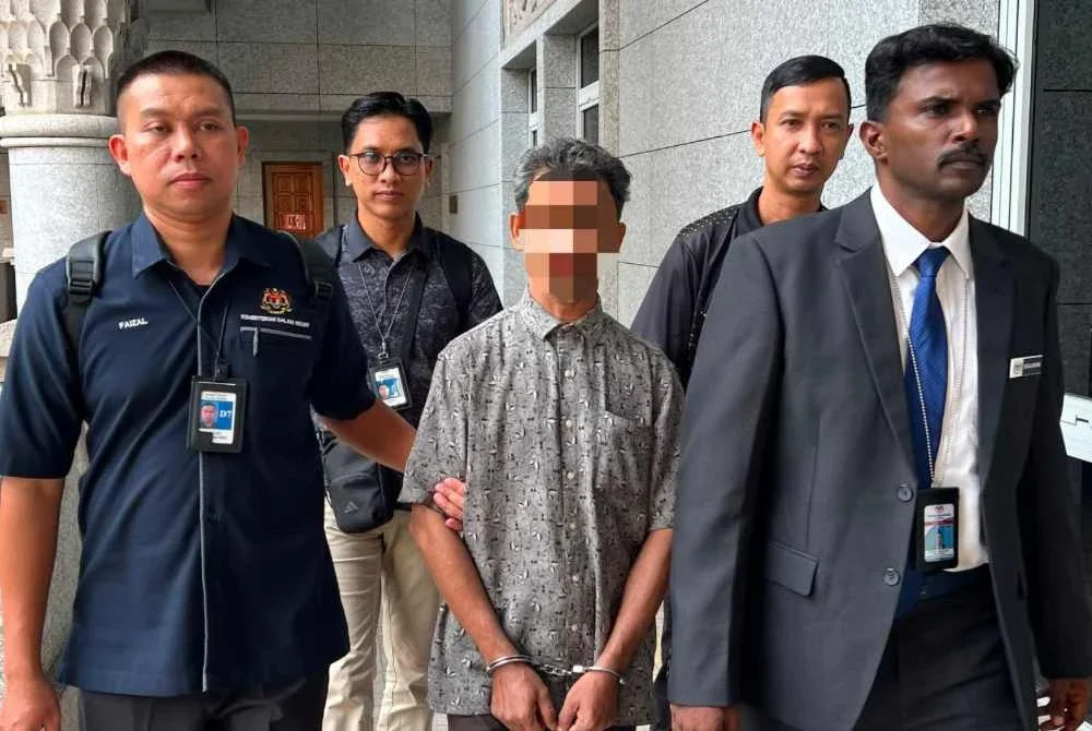 Zafar Ahmad (tengah) dibawa ke Mahkamah Majistret Putrajaya pada Rabu.