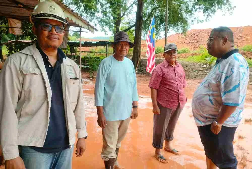 Mohd Haniff (kiri) memantau lokasi rumah penduduk yang terjejas.