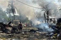 Penduduk meredah kepulan asap dan serpihan selepas serangan udara junta di sebuah pasar serta jambatan berdekatan di Kyauktaw, Rakhine. - Foto: AFP