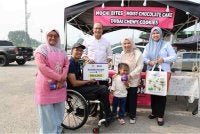 Norliza (dua dari kiri) menyantuni keluarga Zaim Zazami dengan menyampaikan sumbangan RM1,000 dalam bentuk Akaun Simpan SSPN Prime di Cyberjaya pada Rabu.