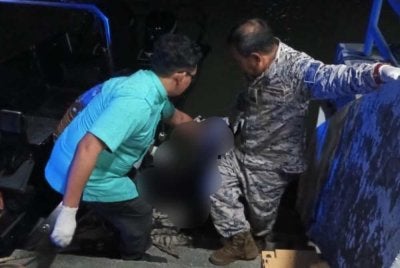 Anggota Maritim Malaysia mengangkat mayat mangsa.