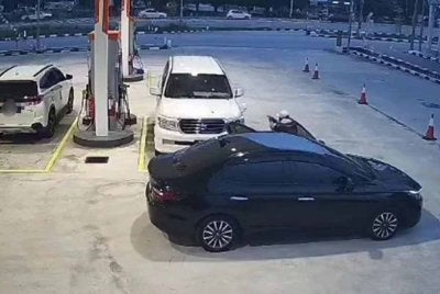 Tangkap layar CCTV memaparkan seorang lelaki mengacukan senjata api ke arah kenderaan mangsa sebelum beredar melarikan diri.