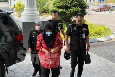 Wanita itu tiba di Mahkamah Alor Gajah untuk reman. 