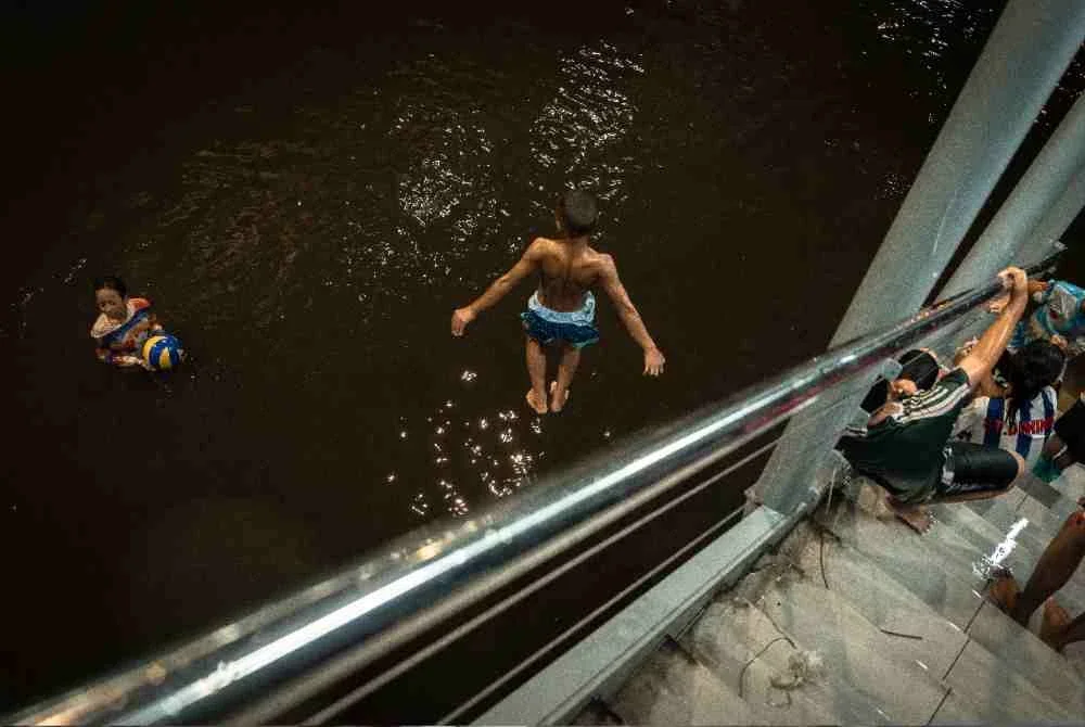 Kanak-kanak bermain di dalam air banjir di daerah Bang Kapi, Bangkok. Foto: AFP