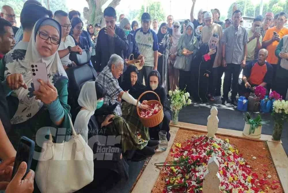 Tun M menabur bunga di atas pusara Dr Hasmah sebagai tanda penghormatan terakhir.