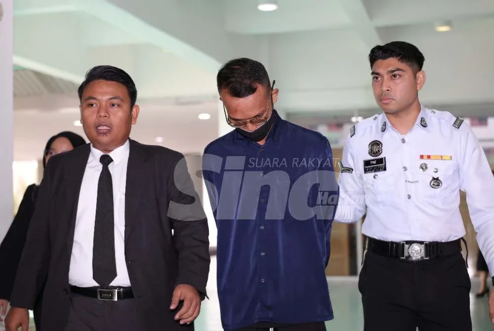 Muhammad Haziq yang memakai baju kemeja berwarna biru dibawa ke Mahkamah Majistret Shah Alam pada Khamis dengan ditemani peguamnya.