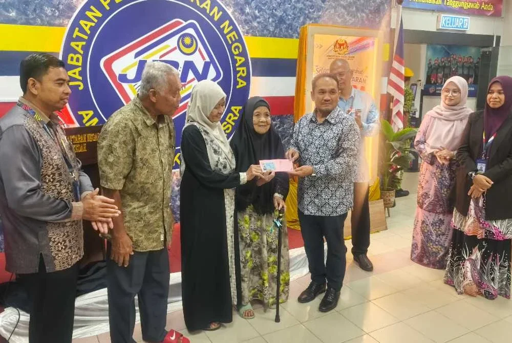 Anuar (empat kanan) menyerahkan MyKad Generasi Baharu kepada Bedah di Jabatan Pendaftaran Negara (JPN) Kedah di Kompleks Pentadbiran Kerajaan Negeri Kedah, Anak Bukit.