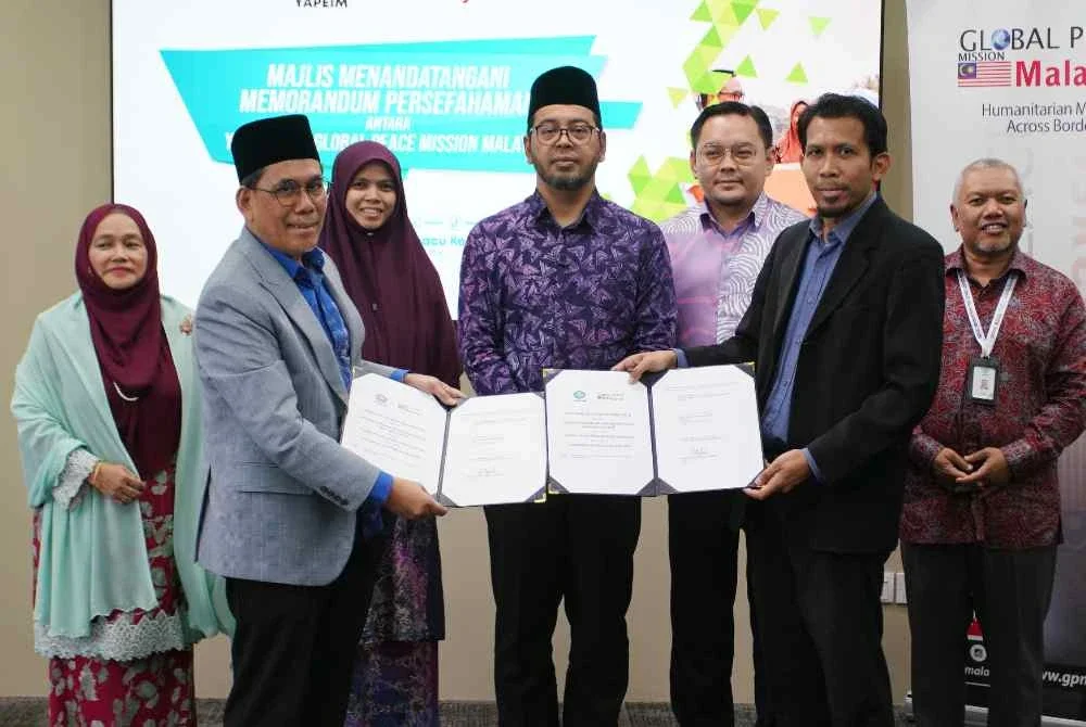 Pengerusi Lembaga Pemegang Amanah YAPEIM, Abdul Khudus Mohd Naaim bertukar dokumen memorandum persefahaman antara YAPEIM dan Presiden Global Peace Mission Malaysia, Mohd Khairul Anwar Ismail pada pelancaran Modul Kecemerlangan Pendidikan SPM 2026. Foto Bernama 