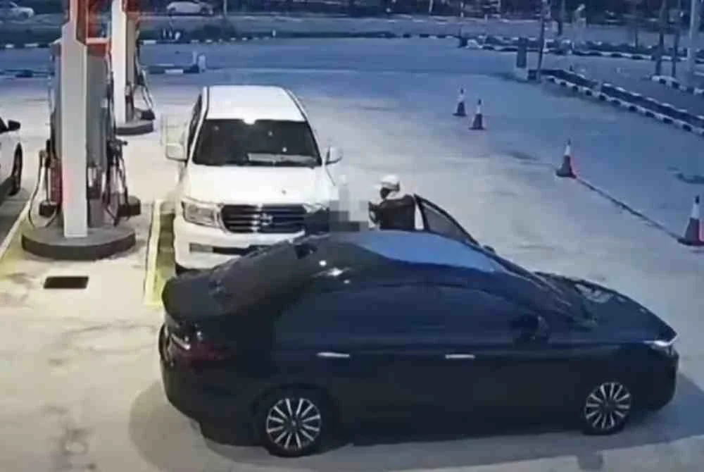Tangkap layar CCTV memaparkan seorang lelaki mengacukan senjata api ke arah kenderaan mangsa sebelum beredar melarikan diri.