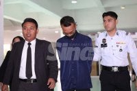 Muhammad Haziq yang memakai baju kemeja berwarna biru dibawa ke Mahkamah Majistret Shah Alam pada Khamis dengan ditemani peguamnya. 