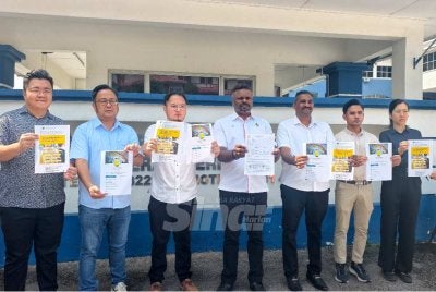 Arul Kumar (empat dari kiri) menunjukkan laporan polis yang dibuat di IPD Seremban