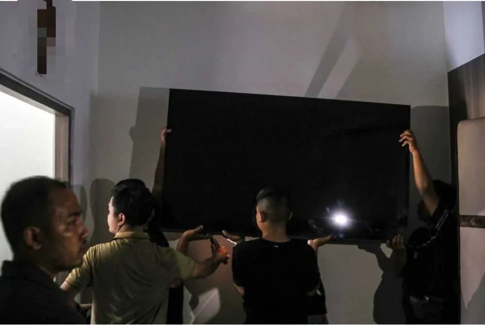 Pihak berkuasa mengangkat televisyen yang turut disediakan dalam bilik istimewa itu. Foto AFP