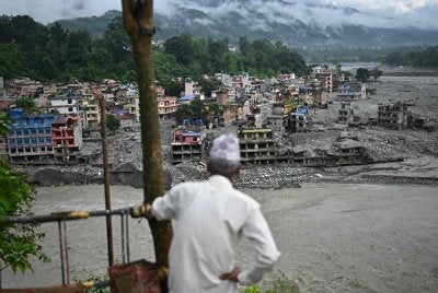 Seorang penduduk melihat sisa-sisa kemusnahan susulan banjir kilat di Trishuli, daerah Nuwakot, Nepal. Foto: AFP