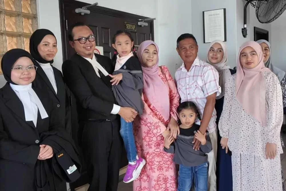 Hanan Qaireen disamping keluarga dan barisan peguam di Mahkamah Tinggi Melaka pada Jumaat.