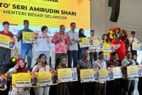 Amirudin (belakang, tengah) bergambar bersama-sama tetamu kenamaan dan penerima semasa Pelancaran Program TUAH di Shah Alam pada Sabtu.