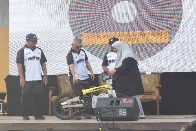 Razali (dua, kiri) menyampaikan hadiah kepada salah seorang pemenang ketika sambutan Hari Alam Sekitar Negara (HASN) 2026 di Pantai Kelulut, Marang pada Sabtu. 