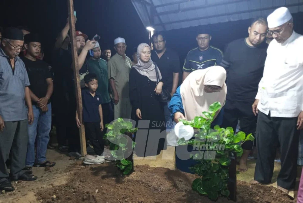 Nenek kepada Allahyarham Irene Sofiya menyiram bunga mawar di atas pusara cucunya.