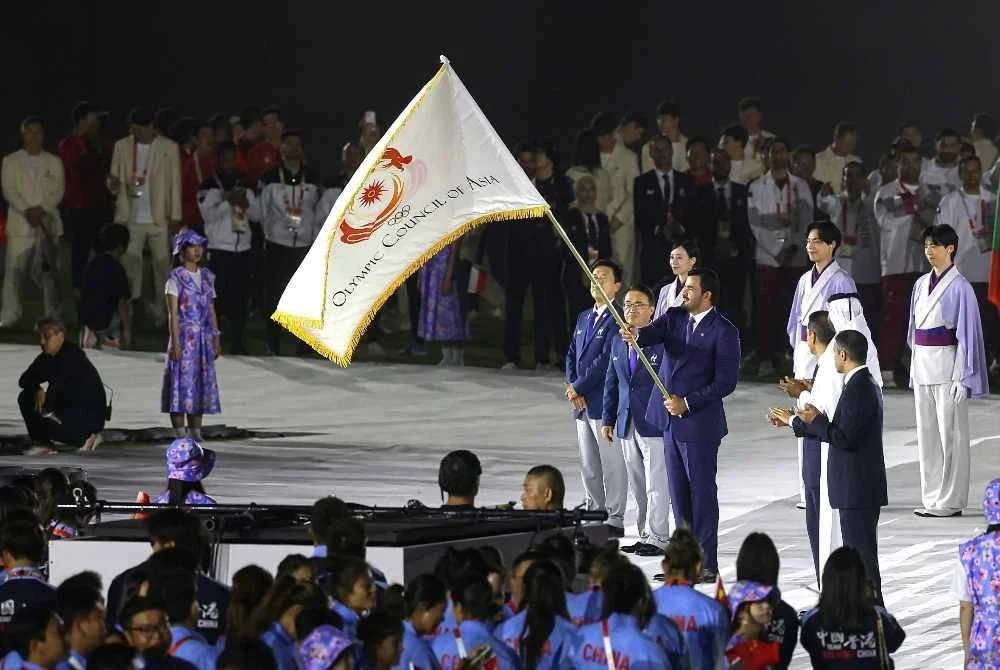 Sheikh Joaan menerima bendera OCA daripada Omura, sekali gus menjadi simbolik penyerahan tuan rumah Sukan Asia seterusnya kepada Doha. - FOTO: Bernama