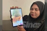 Rosnani (kanan) menunjukkan gambar kecederaan anaknya. Foto SINAR HARIAN / ADILA SHARINNI WAHID