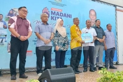 Kulasegaran (tiga dari kanan) menyampaikan cek cura kepada penerima sempena Program Madani Kita 2026 Bersama Komuniti Buntong di Dewan Orang Ramai Kampung Tersusun Jalan Sungai Pari pada Ahad.