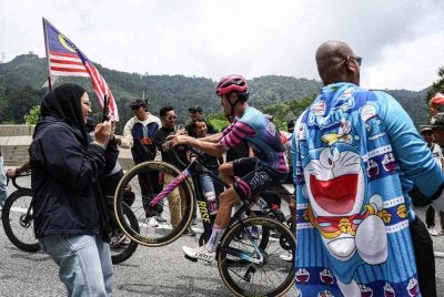 Auge melakukan aksi 'wheelie' ketika mendaki laluan berselekoh pada perlumbaan LTdL 2026 peringkat kelima dari Tapah ke Genting Highlands. - FOTO: Bernama 