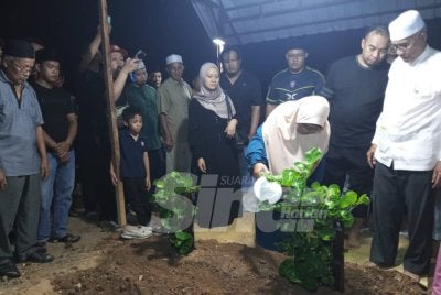 Nenek kepada Allahyarham Irene Sofiya menyiram bunga mawar di atas pusara cucunya. 