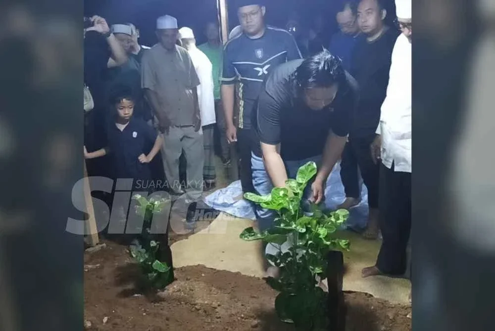 Mohd Khairool menyiram air di pusara anaknya di Tanah Perkuburan Islam Kampung Parit Arshad, Yong Peng.