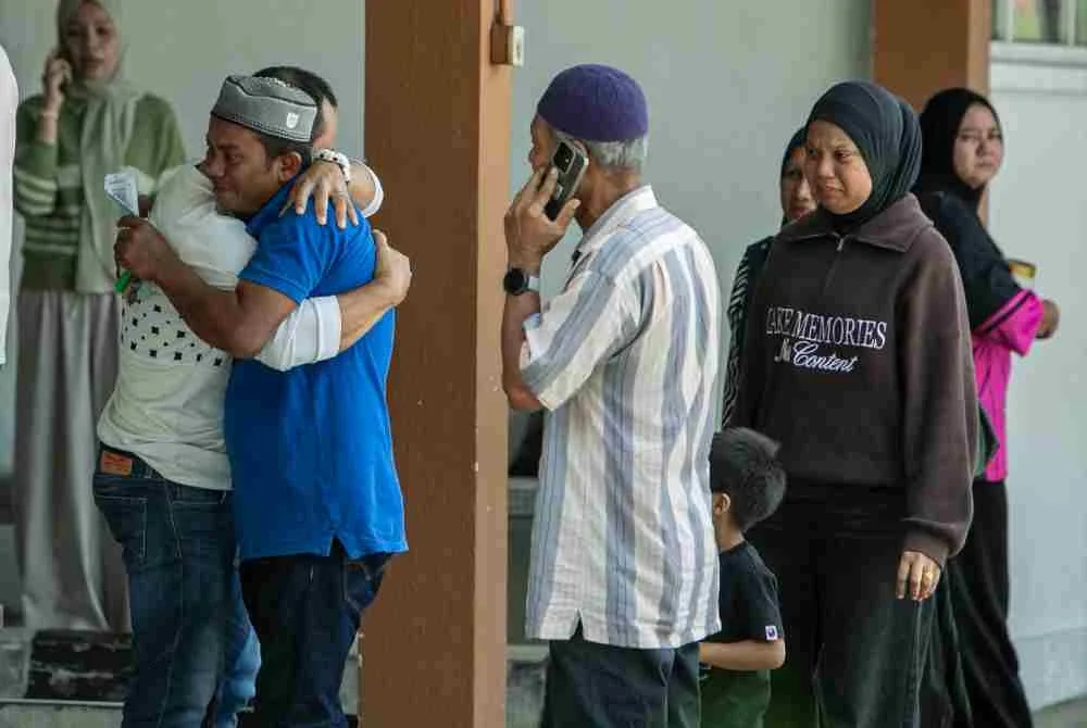 Ahli keluarga dan saudara-mara mangsa tidak dapat menahan sebak di Jabatan Forensik Hospital Taiping, pada Isnin. Foto Bernama