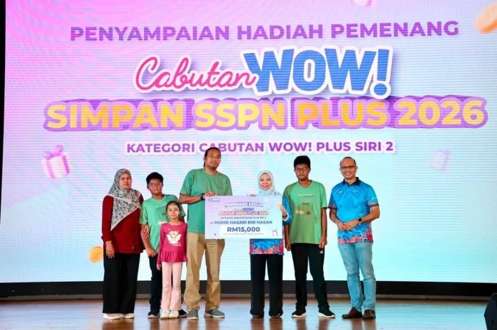 Norliza (tiga dari kanan) menyerahkan replika kad berjumlah RM15,000 kepada pemenang kedua Cabutan WOW! Simpan SSPN Plus 2026 Kategori Cabutan WOW! Plus Siri 2.