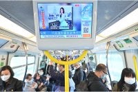 Orang ramai melihat laporan berita mengenai model dan pempengaruh Hong Kong, Abby Choi menerusi skrin di dalam sebuah kereta api di Hong Kong pada Februari 2023. Foto: AFP