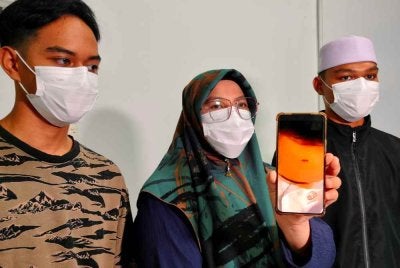 Noor Azwani menunjukkan gambar kecederaan dialami anaknya yang didakwa dibuli rakan di sekolah terbabit.