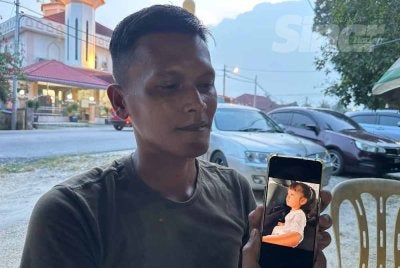 Mohamad Sanuzi yang menunjukkan gambar dikirim bekas isteri sebelum kemalangan bersama anak mereka.