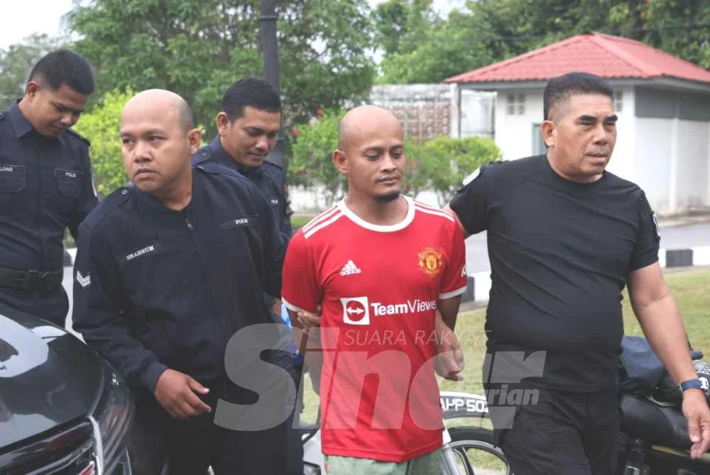 Mohd Rezuan (dua dari kanan) tiba di mahkamah untuk mendengar pertuduhan. 