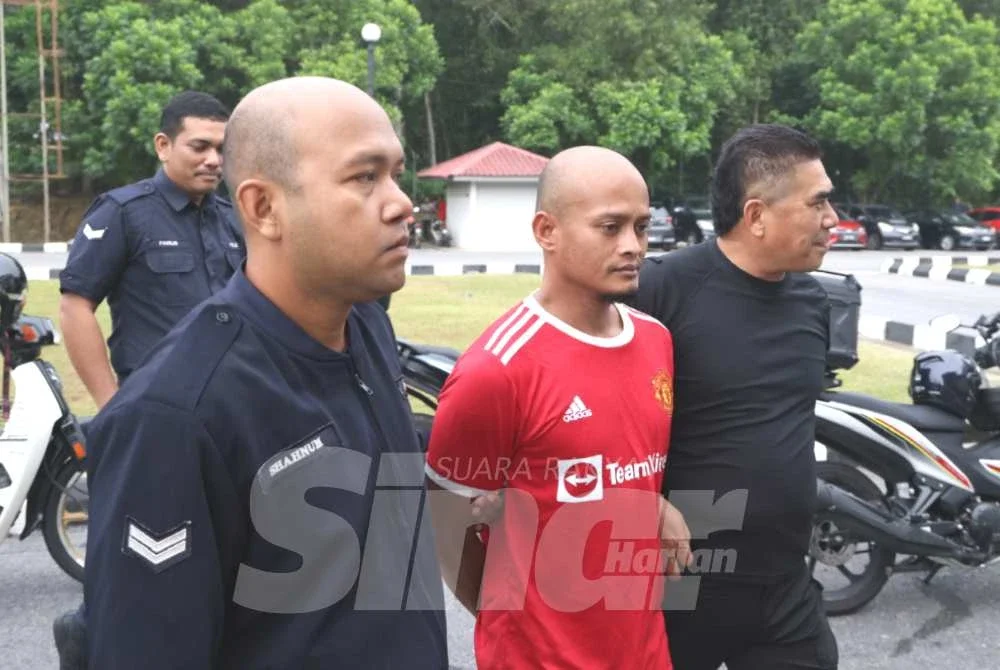 Mohd Rezuan (dua dari kanan) diiringi pihak polis semasa di Mahkamah Kuala Krai. 